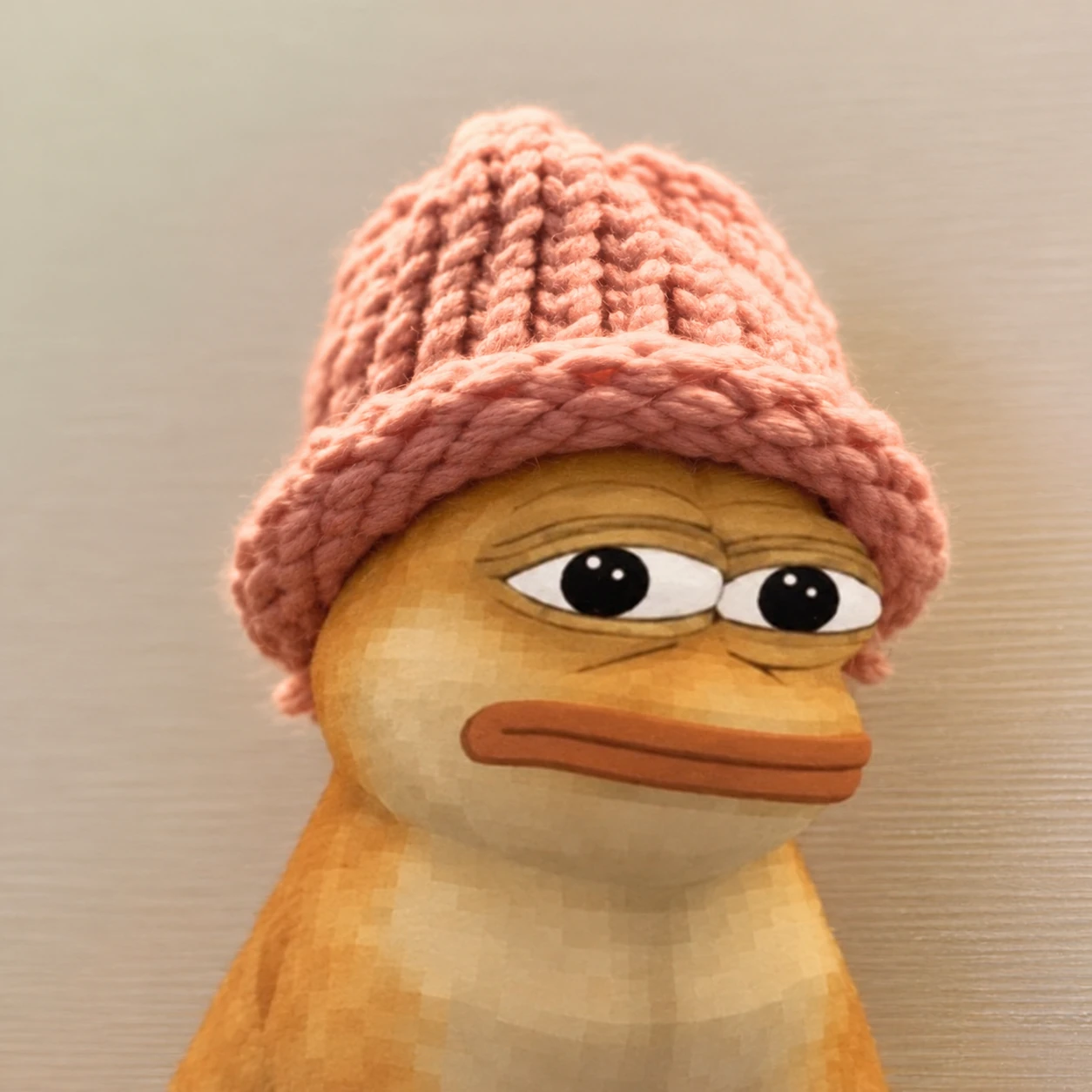 Yellow dope character with skeptical eyes wearing an oversized pink knitted beanie